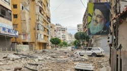 O fotografie cu Hassan Nasrallah – liderul grupării Hezbollah cu sediul în Liban, ucis într-un atentat cu bombă israelian în 2024 – atârnă de o clădire, după un atac israelian din 25 martie în suburbiile sudice ale Beirutului.