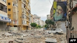 A photo of Hassan Nasrallah -- the leader of Lebanon-based Hezbollah who was killed in an Israeli bombing in 2024 -- hangs from a building following an Israeli strike in Beirut’s southern suburbs on March 25.
