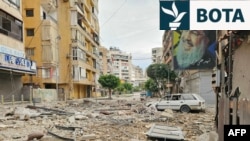 Një fotografi e Hassan Nasrallahut - udhëheqësit të Hezbollahut me bazë në Liban, i cili u vra në një bombardim izraelit në vitin 2024 - në një ndërtesë pas një sulmi izraelit në periferitë jugore të Bejrutit më 25 mars.