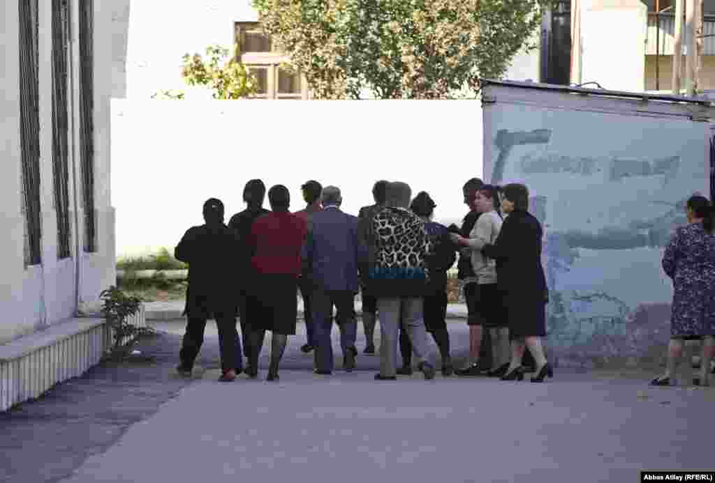 179 nömrəli məktəbin ön tərəfində yerləşən 10 saylı Binəqədi III seçki dairəsinin 8 saylı seçki məntəqəsindən çıxan bir qrup şəxs məktəbin arxasında yerləşən 7 saylı məntəqənin yanında 7 saylı məntəqə komissiyasının üzvünə qulaq asırlar. Komissiya üzvünün təlimatı belədir: Heç kimə şəxsiyyət vəsiqənizi göstərməyin və heç kimin sualına cavab verməyin.