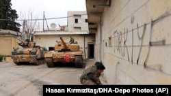 Afrin, nord-vestul Siriei, un militar sirian scrie „Turcia” pe un zid, 18 martie 2018