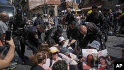 Policia duke i shpërndarë protestuesit që bllokuan rrugën në Jerusalem në 9-mujorin e fillimit të luftës, dhe bënë thirrje për lirimin e pengjeve që po mbahen në Gazë, e diele, 7 korrik 2024.
