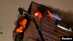 Firefighters work at the scene of a Russian drone attack in Kyiv on October 25.