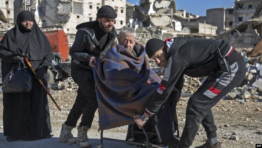 An elderly Syrian man is carried during an evacuation operation of rebel fighters and their families from rebel-held neighborhoods in the embattled city of Aleppo on December 15.