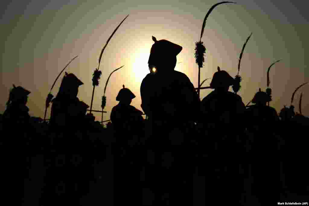 Performers are silhouetted as they stand during a Qing Dynasty ceremony, in which emperors prayed for a good harvest and fortune, at a temple fair in Beijing&#39;s Ditan Park on February 5. (AP/Mark Schiefelbein)