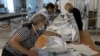 A választási bizottság tagjai egy urnát ürítenek ki a referendum után Szevasztopolban, a Krímben 2022. szeptember 27-én. Ebben a szavazókörben az úgynevezett Donyecki Népköztársaság elmenekült lakosai voksolhattak