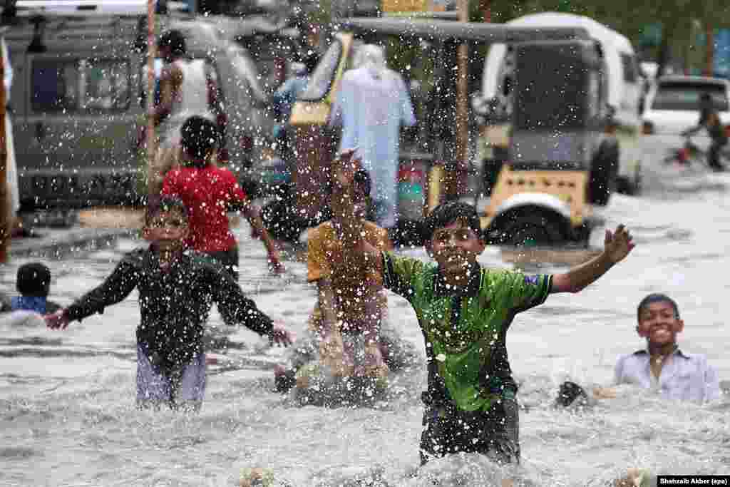 Street children enjoy themselves as the monsoon rains flood the streets of Karachi, Pakistan. (epa/Shahzaib Akber)