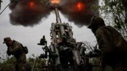 Un grup de soldați ucraineni manevrând un tun Howitzer în regiunea Harkov, Ucraina, 21 iulie 2022.
