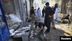 Police collect evidence at the site of the suicide bomb attack in Pabbi on July 26.