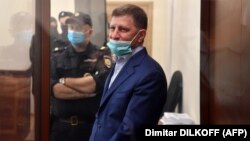 Khabarovsk Governor Sergei Furgal stands inside a defendants' cage during a court hearing in Moscow on July 10. 
