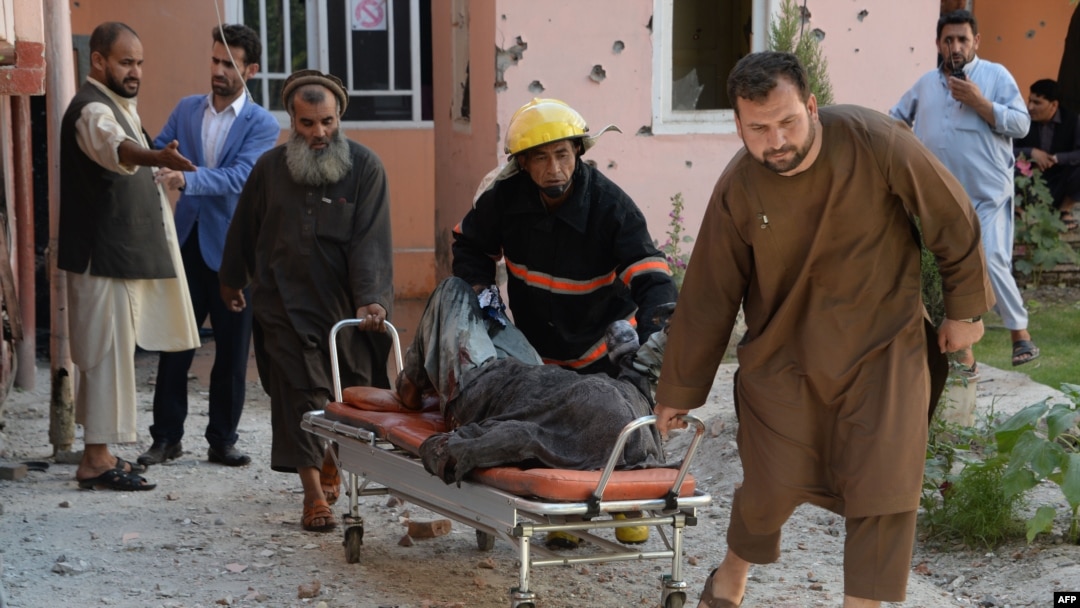 A body is removed from the scene of a suicide attack that targeted the Afghan state television building in Jalalabad in May.