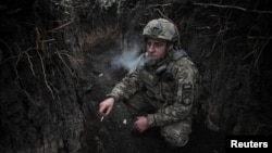 Артилерист 44-ї ОАБр ім. гетьмана Данила Апостола курить в окопі перед вогневою роботою у бік російських військ, Дніпропетровська область