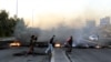 Demonstrators burn tires to close a way in central Karbala city, southern Iraq, 24 December 2019. 