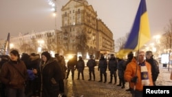 Ukrainian police keep tax protesters under tight watch after shutting down their tent camp in downtown Kyiv on December 3.