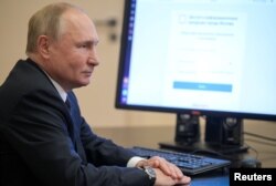 Russian President Vladimir Putin votes online at his residence outside Moscow.