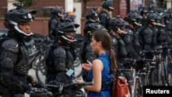 Журналістка задае пытаньне паліцыянту падчас пратэсту 17 ліпеня, напярэдадні зьезду рэспубліканцаў у Кліўлэндзе.