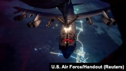 Стратегический бомбардировщик B-52 ВВС США получает топливо от самолета-заправщика KC-135 во время войны с Ираном, где-то в небе над Ближним Востоком. 26 марта 2026 года