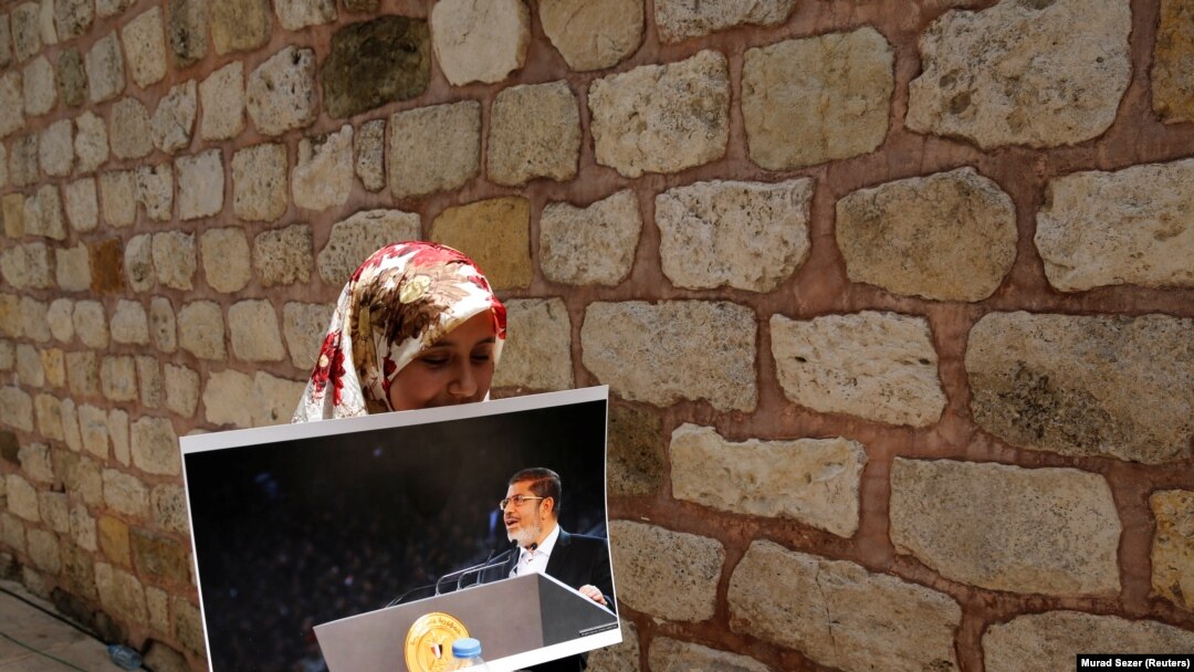 Žena nosi fotografiju preminulog bivšeg egipatskog predsednika Mohameda Morsija, ilustrativna fotografija