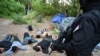 Migranti sa rukama na glavama, nakon što je srpska policija otkrila ilegalni kamp u opštini Novi Kneževac na severu Srbije. Ovu fotografiju objavila je srpska policija, 4. jula 2021. 