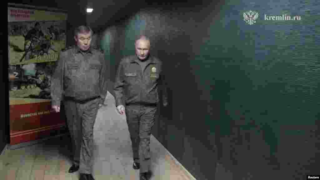 Президент России Владимир Путин и начальник Генерального штаба ВС России Валерий Герасимов проходят по командному пункту группировки "Запад" российских войск в ходе российско-украинского конфликта в неустановленном месте. Kremlin.ru 