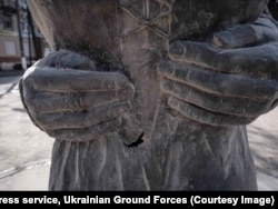 A detail of the Druzhkivka statue showing damage after air strikes impacted buildings nearby.