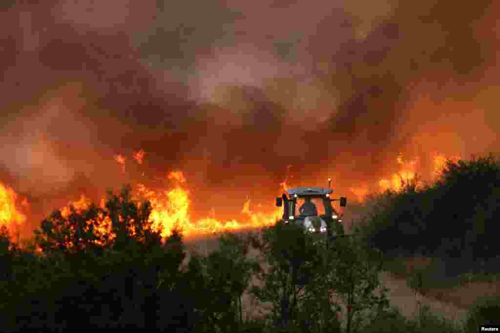 A tractor cuts a fire line as a wildfire burns near the settlement of Beledie Han in Bulgaria.