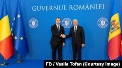 Premierii R. Moldova și a României, Vasile Tofan (stânga) și Ilie Bolojan, își strâng mâinile la sediul Guvernului României, în timpul primei vizite externe a prim-ministrului moldovean, București, 30 iulie 2026
