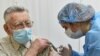 UKRAINE -- An elderly man receives a dose of the Oxford University/AstraZeneca vaccine against the coronavirus disease (COVID-19), which is produced in India and marketed as Covishield, at a local clinic in Lviv, March 24, 2021