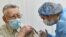 UKRAINE -- An elderly man receives a dose of the Oxford University/AstraZeneca vaccine against the coronavirus disease (COVID-19), which is produced in India and marketed as Covishield, at a local clinic in Lviv, March 24, 2021
