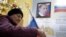 A woman casts her ballot in front of a portrait of Russian President Vladimir Putin at a polling station at a local school in Moscow on September 18.