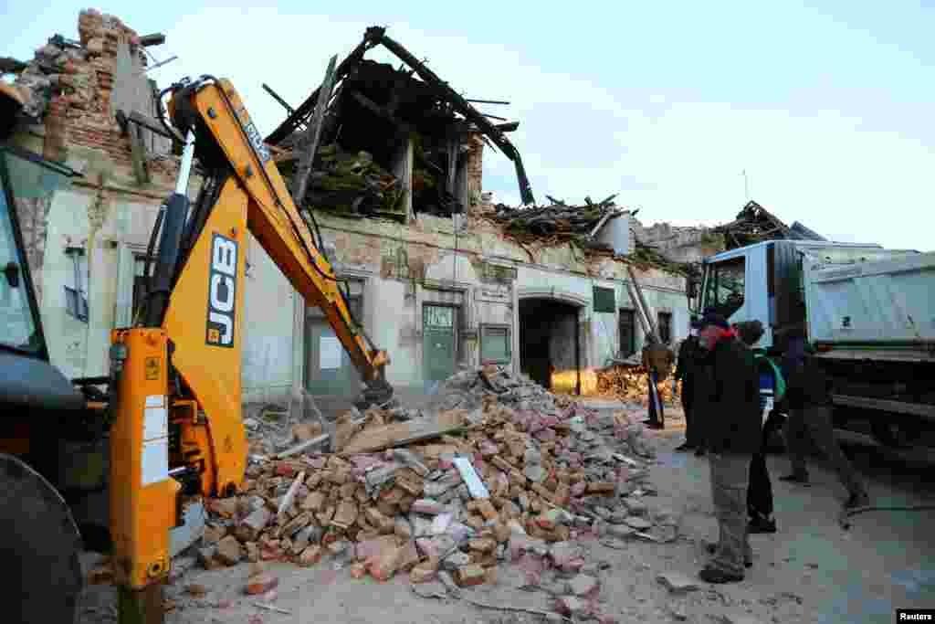Работници чистат остатоци во близина на оштетена зграда по земјотресот, во Петриња, Хрватска, 29 декември 2020 година.