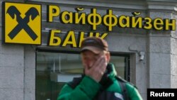 Russia -- A pedestrian walks past a branch office of Raiffeisen Bank in Moscow September 25, 2014.