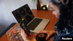 O femeie iraniană vorbește la telefon prin WhatsApp într-o cafenea, după ce s-a anunțat redeschiderea accesului la internet internațional, la Teheran, Iran, pe 27 mai 2026.