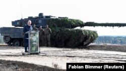 Cancelarul german Olaf Scholz ține un discurs în fața unui tanc Leopard 2 în timpul unei vizite la baza militară Bundeswehr din Bergen, Germania, 17 octombrie 2022.