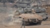 Israeli armored personnel carriers and tanks maneuver in a staging area in northern Israel near the Israel-Lebanon border on October 1.