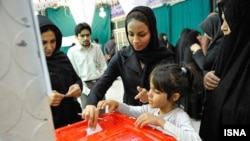 Женщины голосуют на избирательном участке во время выборов президента Ирана. 14 июня 2013 года.