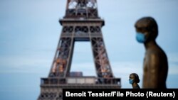 Statujat pranë Kullës Eiffel në Paris.