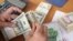 Dollars, euros and Iranian currency as a trader counts money. Undated