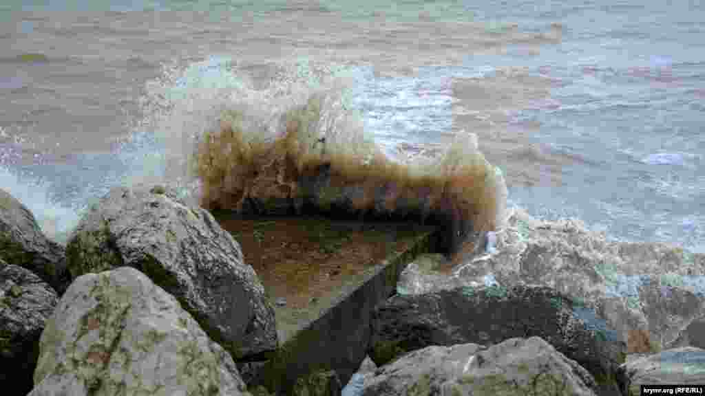 Волны разбиваются о бетонные плиты и камни на территории пляжной зоны базы