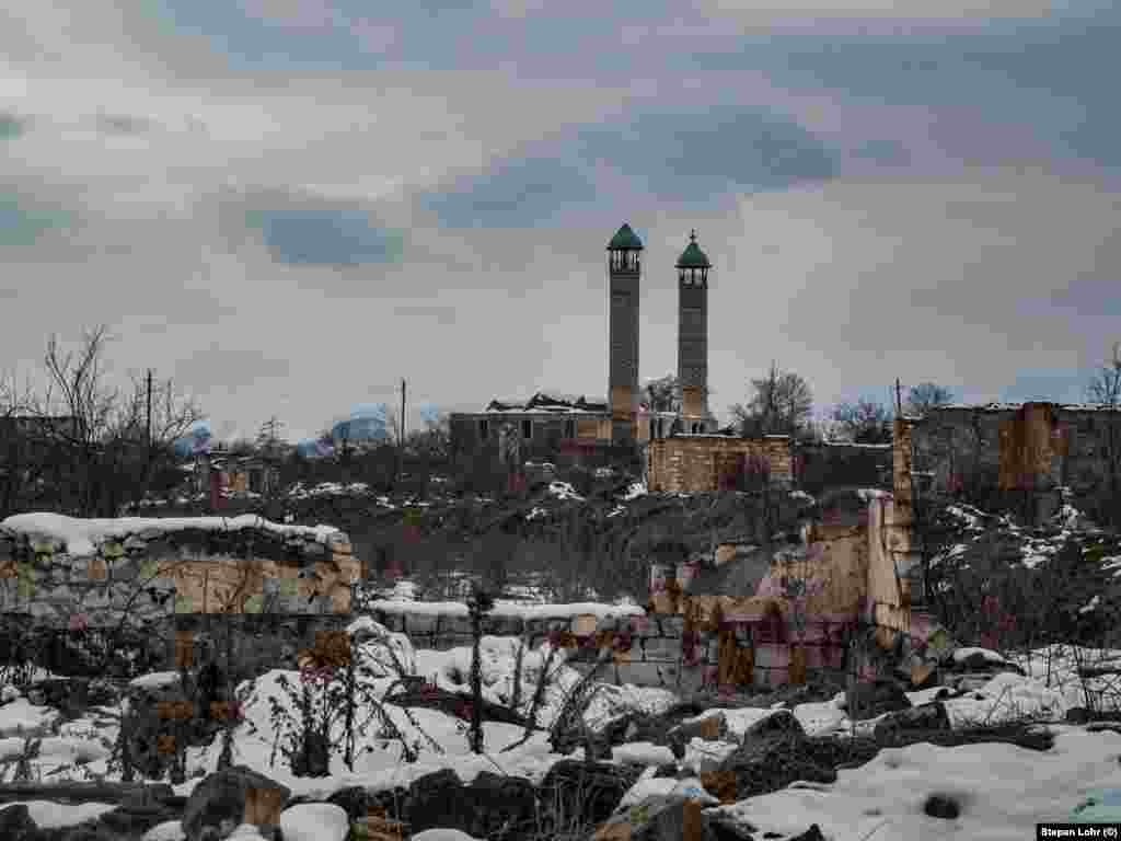 A fő mecset minaretjei a megsemmisült város felé tornyosulnak.