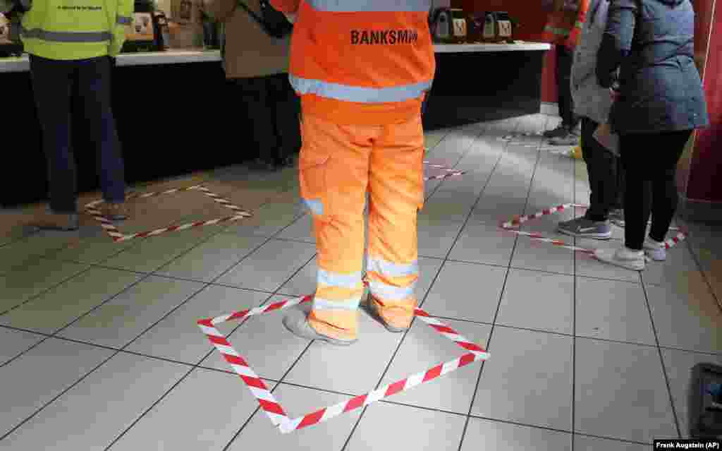 People stand in marked spots at a fast-food restaurant in London on March 20.