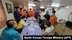 دیدار مقام رسمی کره جنوبی (وسط، با لباس زرد) با خدمه کشتی توقیف‌شده این کشور در آب‌های ایران