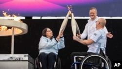 Paralimpikët britanikë, Helene Raynsford dhe Gregor Ewan, e ndezin flakadanin paralimpik në Stoke Mandeville, i cili cilësohet nga shumë si vendlindja e Lojërave Paralimpike, Angli, 24 gusht 2024.