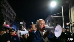 Liderul Partidului Socialist, Igor Dodon, folosește un megafon pentru a se adresa unei mici adunări de protestatari în fața Comisiei Electorale Centrale (CEC), acuzând fraudă electorală.
