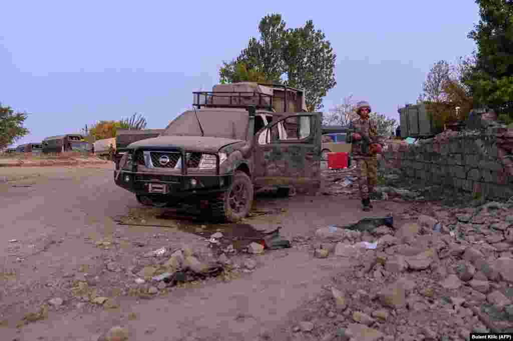 An Azerbaijani soldier walks past a damaged vehicle in Jabrayil on October 16.