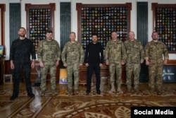 По центру президент України Володимир Зеленський. Ліворуч від нього – колишній головком Олександр Сирський. Праворуч – новий головнокомандувач ЗСУ Михайло Драпатий