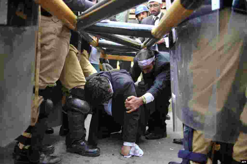 Pakistani lawyers take cover as police stop them from reaching the U.S. Embassy during a protest against the controversial film &quot;The Innocence of Muslims&quot; in Islamabad on September 19. Up to 500 Pakistani lawyers managed to enter the heavily guarded diplomatic enclave in a fresh wave of protests denouncing the film. (AFP/ Aamir Qureshi) 