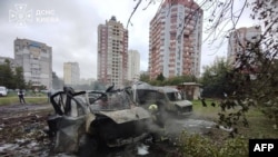Na fotografiji koju su objavile ukrajinske službe za vanredne situacije 24. septembra, ukrajinski spasilac radi pored izgorjelih automobila na lokaciji vazdušnog napada u Kijevu.