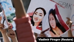 People hold placards during a rally in front of the Kyrgyz Interior Ministry in Bishkek in April 2021, demanding the resignation of its leadership after the killing of kidnapped bride Aizada Kanatbekova amid alleged inaction of police.