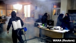 A firefighters wears a protective face mask, amid fear of coronavirus disease (COVID-19), as he disinfects a municipality building, ahead of the Iranian New Year Norouz, in Tehran, March 18, 2020